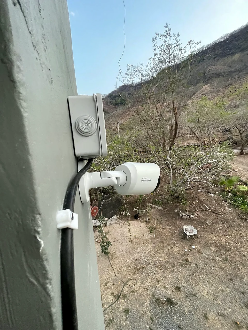 Cámara bala Dahua en la esquina de una casa de campo, cuidando el terreno