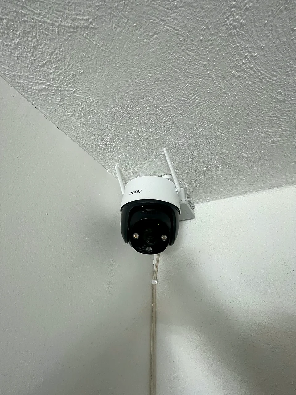 Cámara Imou en esquina de techo interior, con cable ordenado